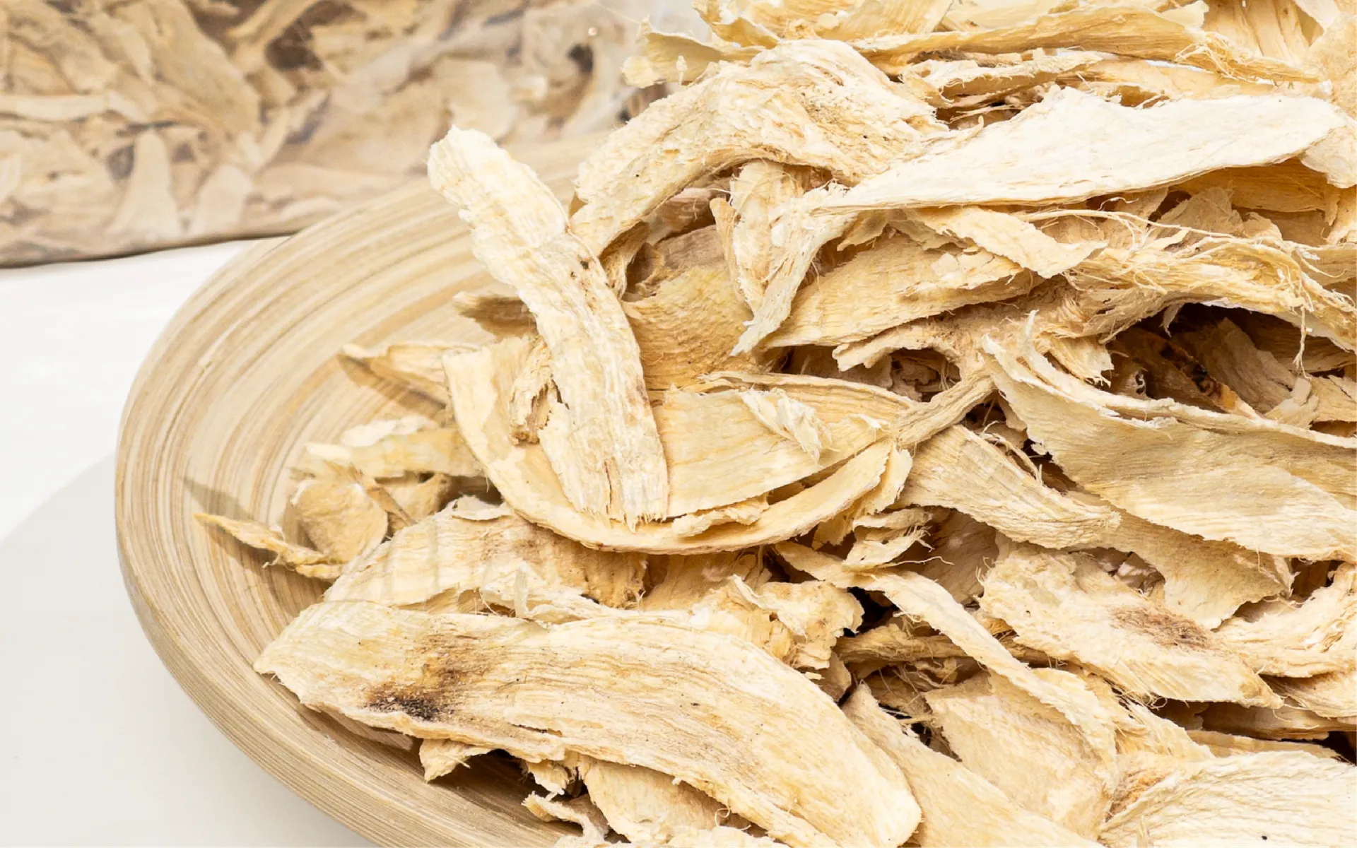 Dried slices of Pueraria mirifica root piled on a bamboo plate